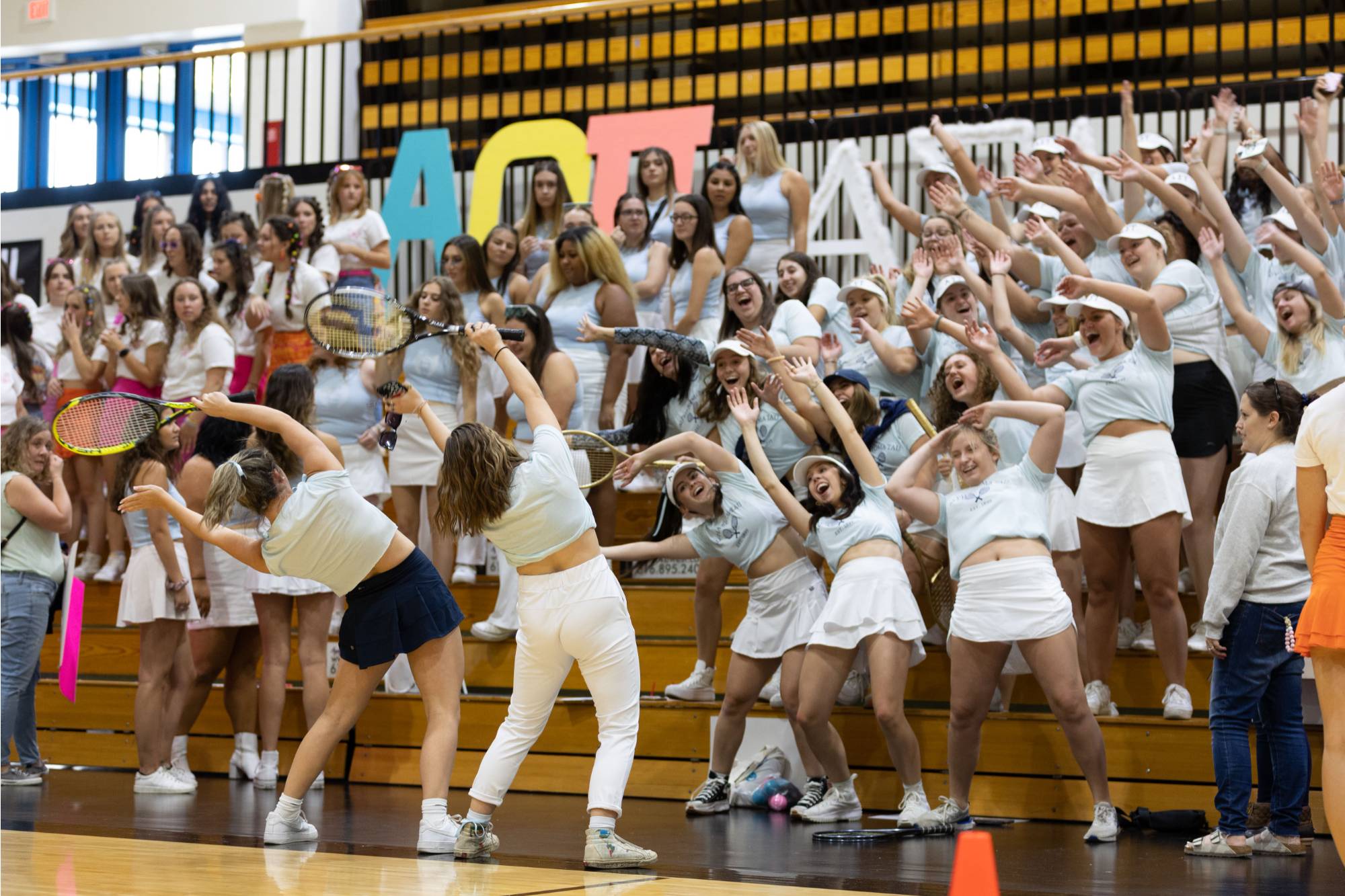 Students wave their hands in the air at Panhellenic Bid Day